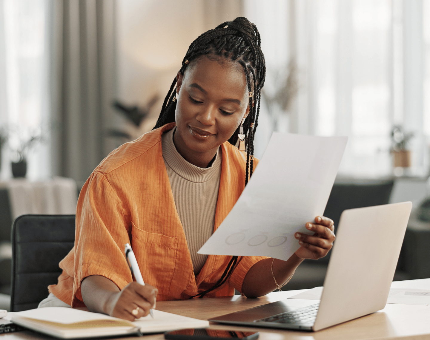 Young Professional Woman Working on Laptop and Taking Notes