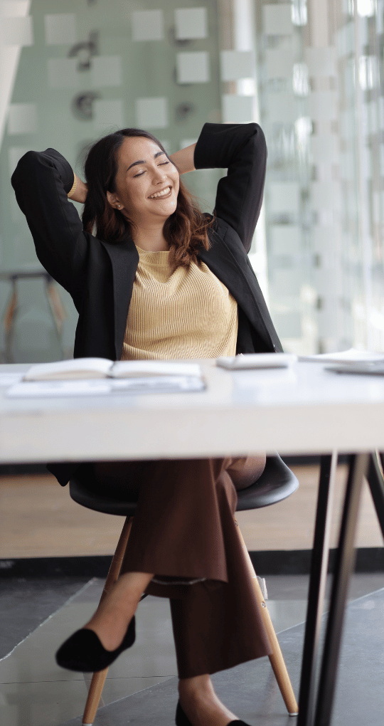 Woman Relaxing in Office with Hands Behind Head