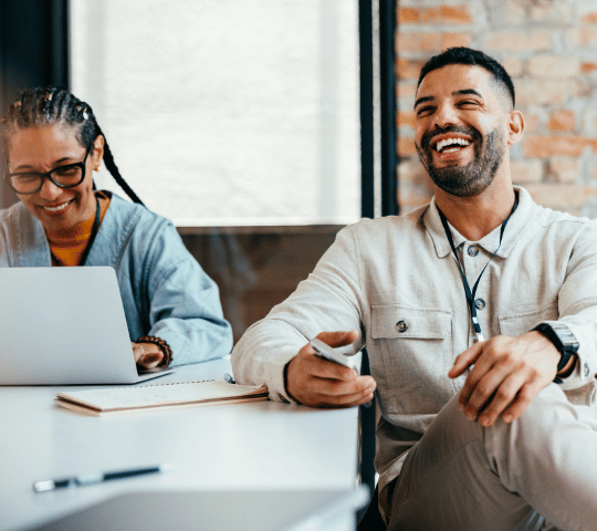 Man and Woman Smiling and Laughing at Office