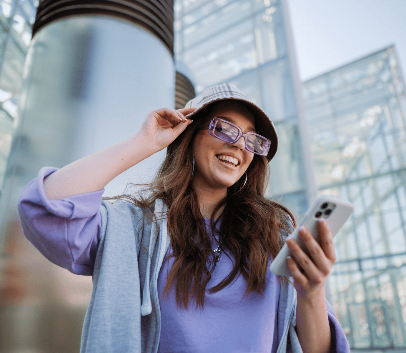 Young Woman Looking at Phone with Cool Purple Glasses and Hat