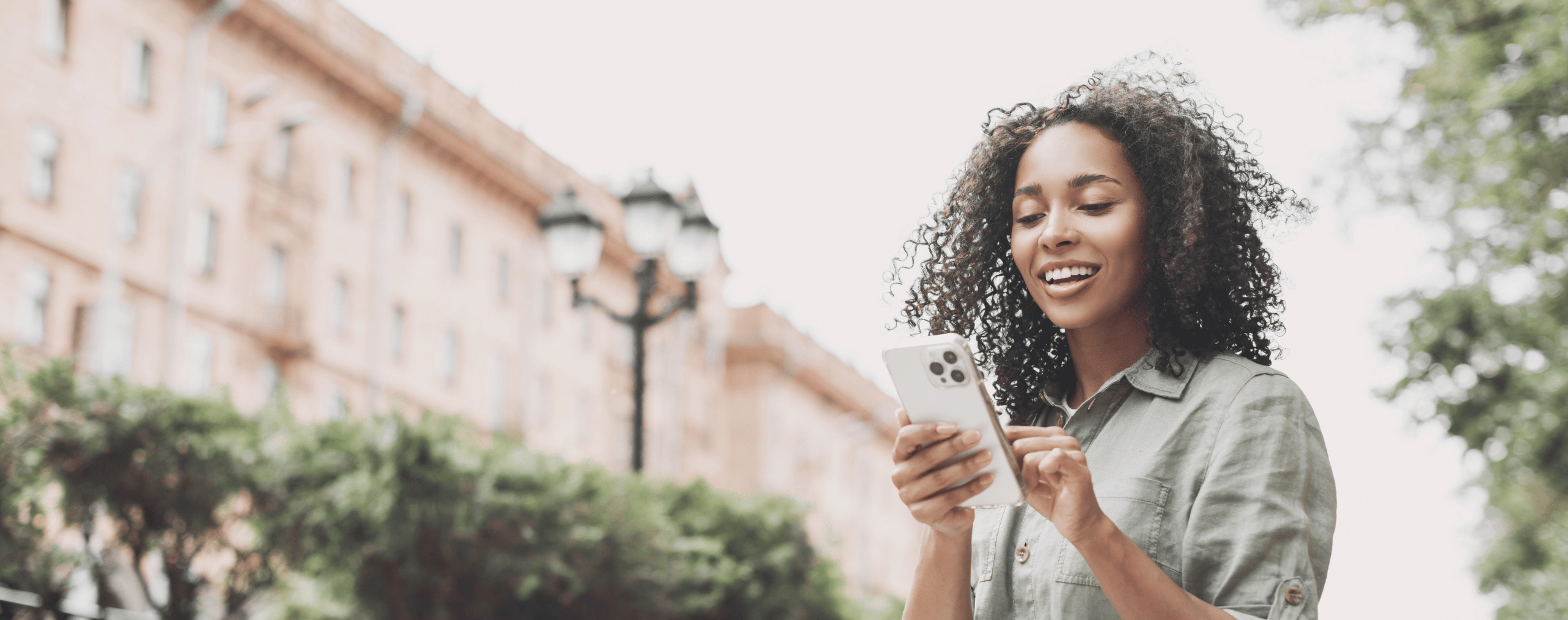Woman Looking at Phone Outside of University
