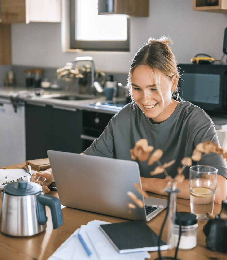 Young Woman in Kitchen on Laptop