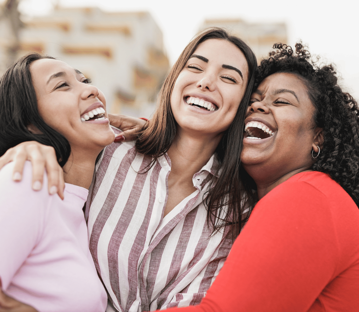 A group of women smiling and laughing outside.